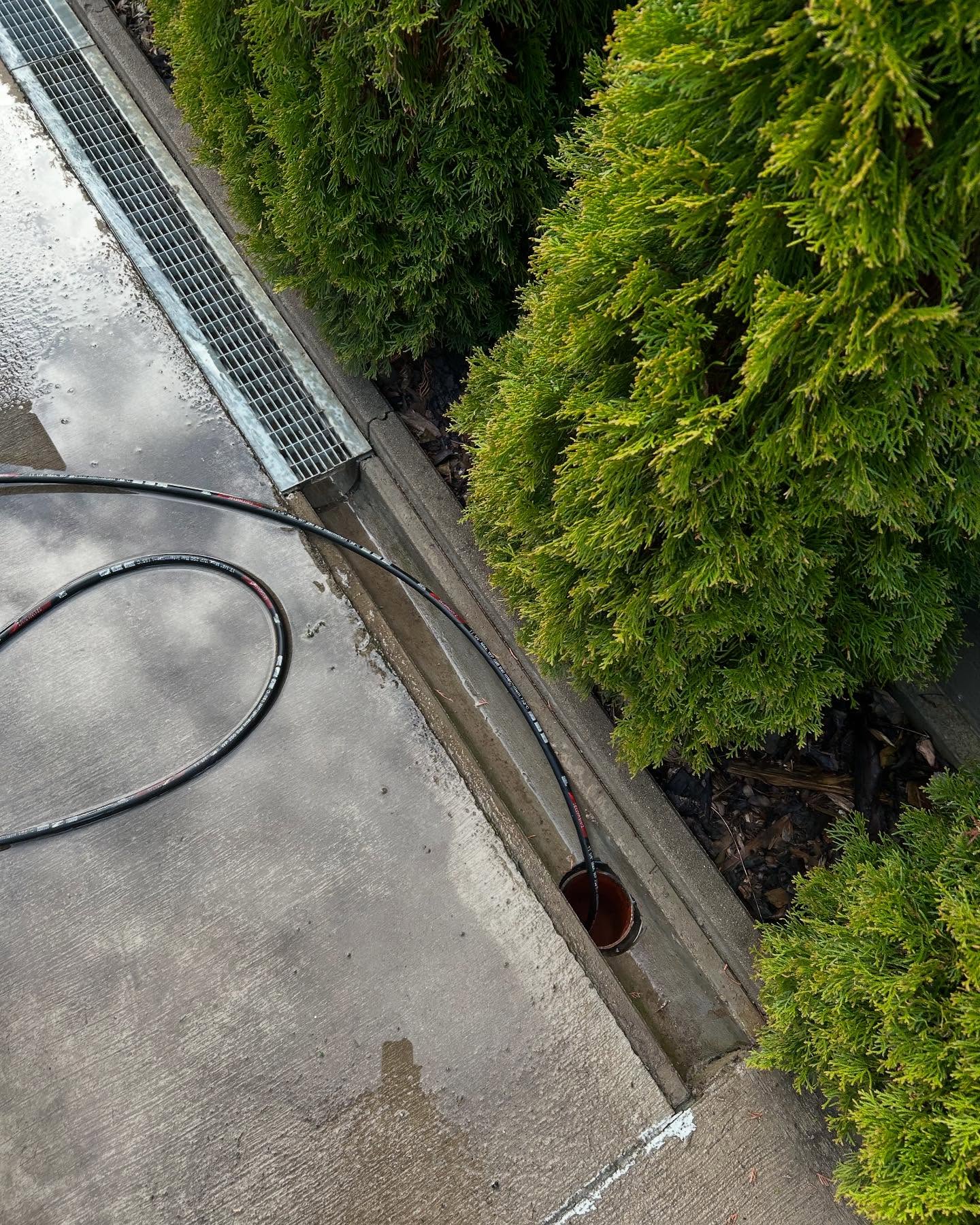 Tlaková hadica v odvodňovacom žľabe pred budovou